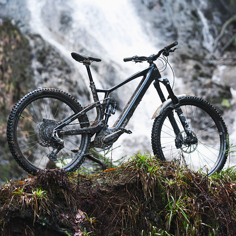 teewing flux one Mountain ebike on a rocky outcrop with a waterfall in the background